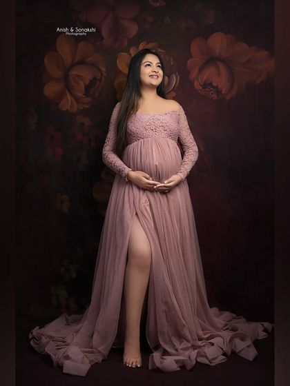Looking towards the future with so much love. This classic maternity pose beautifully showcases the baby bump in an elegant, off-the-shoulder gown.