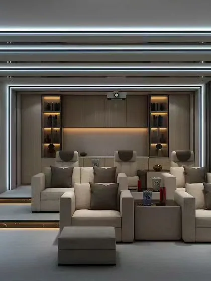A state-of-the-art home theater designed for an immersive cinematic experience. The room features tiered seating with comfortable lounge chairs, professional-grade lighting, and acoustically designed walls to ensure premium sound quality.
