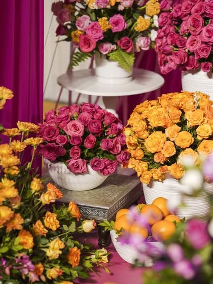 A lush arrangement of flowers in shades of pink, orange, and yellow, showcasing the variety and abundance of blooms used in the Mehendi decor.