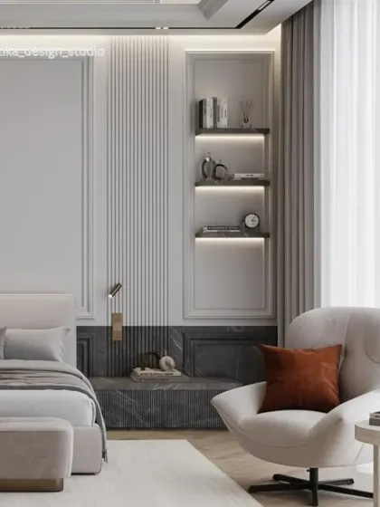 This bedroom showcases a more luxurious and sophisticated aesthetic, using a palette of soft neutrals, rich textures, and elegant details. We incorporated fluted wall paneling, built-in backlit shelving, and a comfortable armchair to create a cozy reading corner, resulting in a space that feels like a high-end hotel suite.
