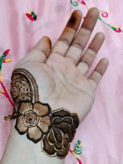 A small but beautiful floral piece on the wrist. This shows how even a few well-placed motifs can create an elegant design.