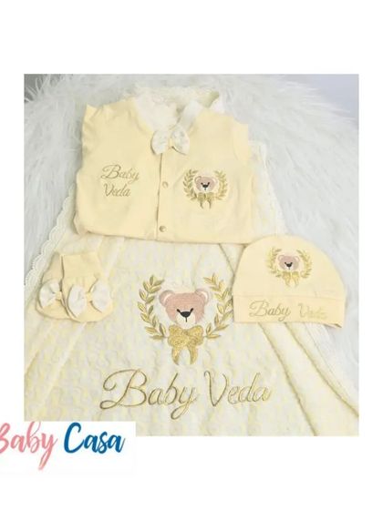 A closer look at the "Baby Veda" set. The soft yellow fabric and delicate embroidery make this a warm and inviting choice for a newborn's first wardrobe.
