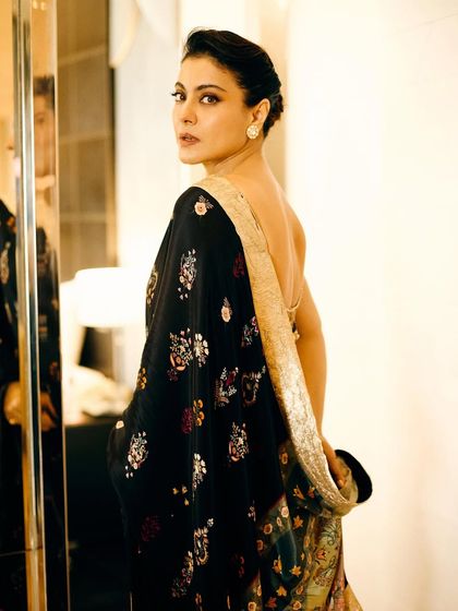 A look over the shoulder reveals the delicate embroidery and the low back of the blouse, adding a touch of modern allure to a traditional garment.