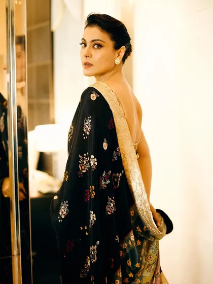 A look over the shoulder reveals the delicate embroidery and the low back of the blouse, adding a touch of modern allure to a traditional garment.