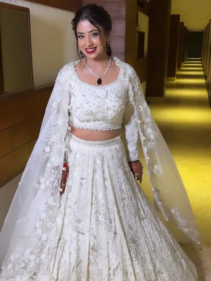 An all-white engagement look with a pop of bold red on the lips. I created a glamorous eye with full lashes and a flawless base to stand up to the intricate white lehenga.