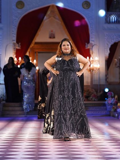 Another view of the black and silver embroidered plus-size gown, showing its movement on the runway.