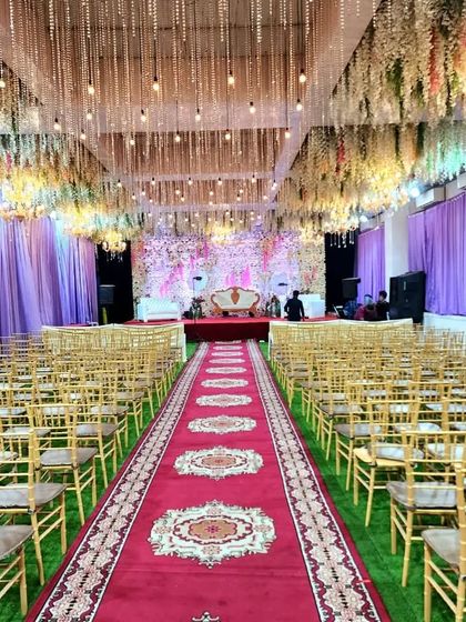 A beautiful banquet setup at a Vashi location, available for just 60k including AC, rent, and decoration. The hanging floral ceiling and green turf flooring create a garden-like feel indoors.