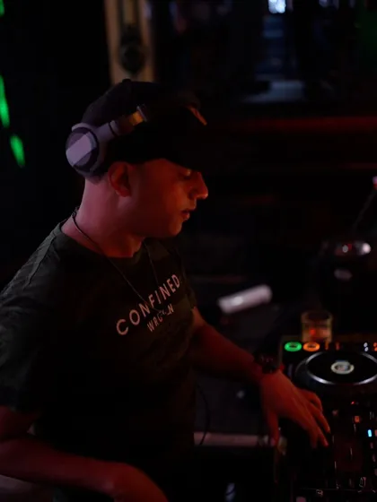 A profile shot of me focused on the mixer at Sugar Factory. Every gig is about precision and passion, ensuring the transitions are seamless and the energy never drops.