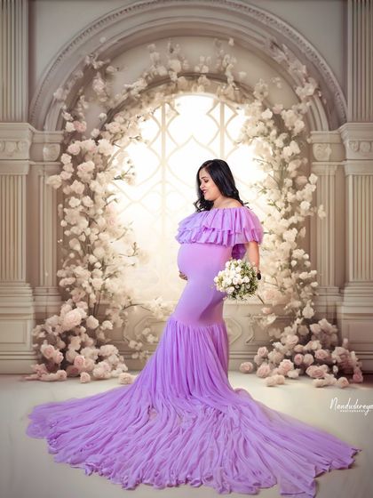 A profile view of the mother-to-be in a lavender gown, standing before a grand floral archway. This shot highlights her beautiful silhouette.