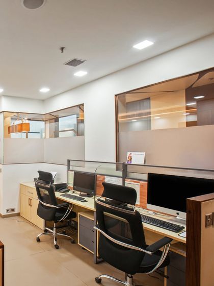 A thoughtfully designed office space nestled within a larger residence, offering both privacy and natural light. The neutral wooden tones are accented with a beautiful pop of orange for warmth.