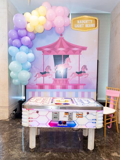 A "Naughty Light Beans" reaction game set against a pastel carousel backdrop, one of our many electronic game offerings.