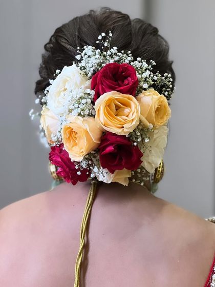 A beautiful shot of the bridal bun, adorned with a mix of colourful roses and baby's breath, showing the attention to detail in hairstyling.