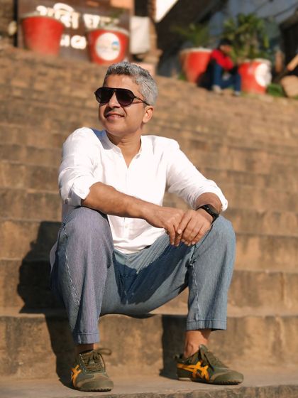Soaking in the sun on the steps of the ghats. A relaxed and candid portrait of a man enjoying the peaceful, timeless atmosphere of Banaras.