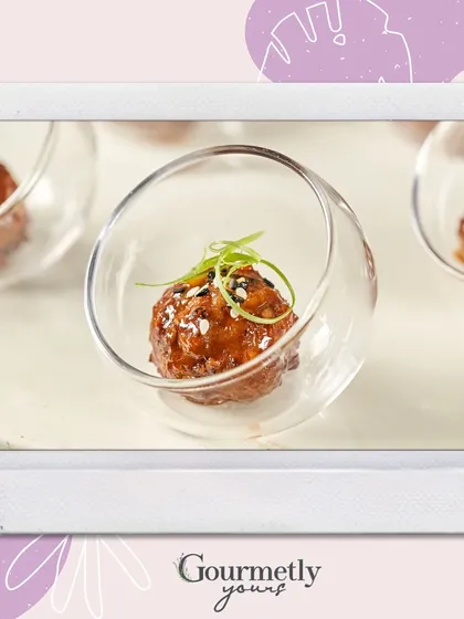 A gourmet meatball served in a stylish, angled glass bowl. This image is part of our "Delight in Every Bite" series, showcasing our elegant and flavorful appetizers.