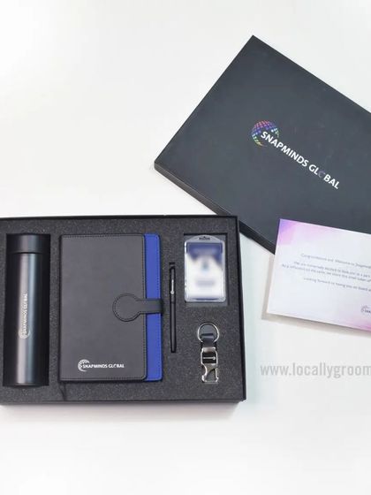We designed this professional joining kit for Snapminds Global. The set includes a branded thermal flask, a notebook and pen, a keychain, and an ID card holder, all neatly arranged in a custom box.