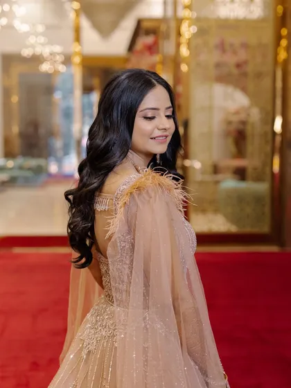The side profile shows off the beautiful soft waves in her hair and the flawless finish of her makeup.