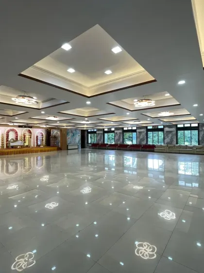 This is an empty view of a 600-seater AC banquet hall in Nerul. The shiny marble floors and modern ceiling design give it a very premium and spacious feel before any decoration is even added.
