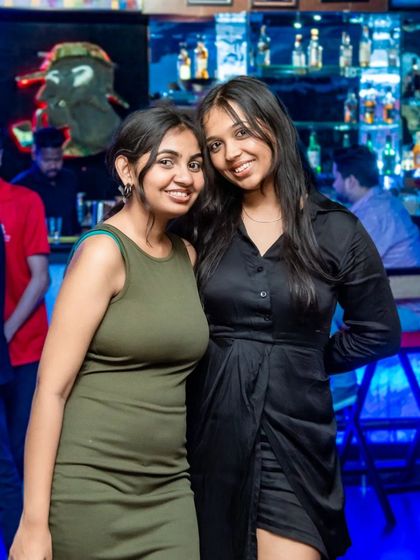 Two friends looking stylish by the bar.