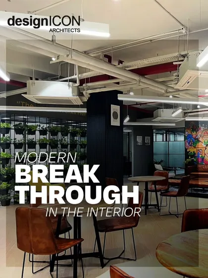 A view of the vibrant breakout and cafe area at the VentureX coworking office. We designed this space with exposed ceilings, modern furniture, and a living green wall to foster a sense of community and provide a refreshing break from the traditional work environment.