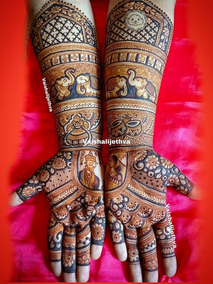 A personalized bridal mehndi featuring portraits of the couple. The design also includes auspicious symbols like the kalash and dhol, along with gentle elephant figures.