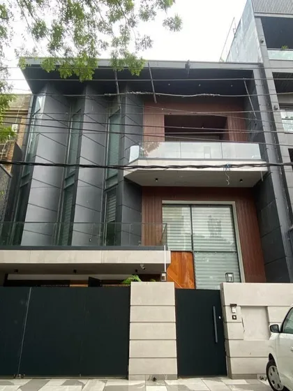 The completed home, photographed from the street, showing the successful translation of our 3D render (image 25). The angled facade and material choices are identical to the plan, demonstrating our precise execution.