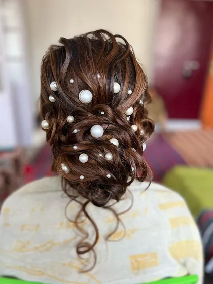 Another angle of the pearl-adorned messy bun, a perfect hairstyle for a cocktail party or reception.