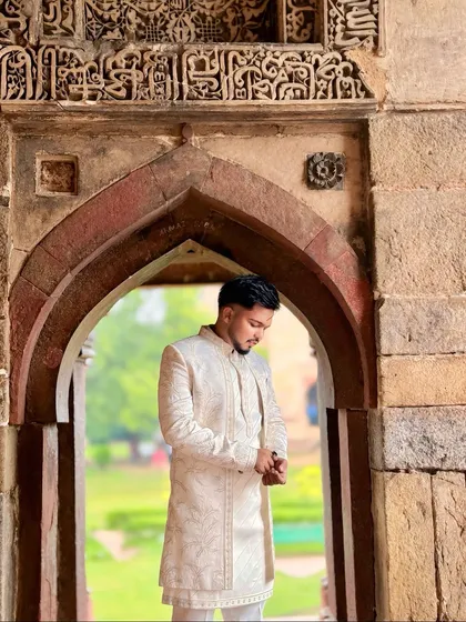 I believe an outfit should complement its setting. Here, my ivory sherwani with its subtle, intricate embroidery stands out against the timeless beauty of historic architecture, creating a picture of grace and sophistication.