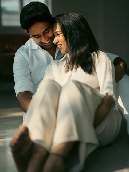 A sun-drenched, intimate portrait of a couple sharing a quiet, happy moment. The warm light and their relaxed posture make this feel very natural and genuine.