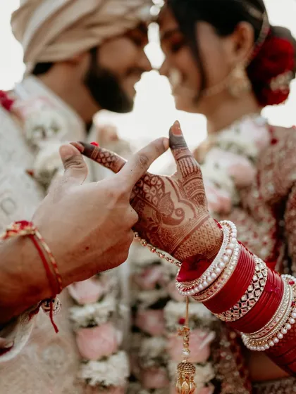 A symbolic gesture of infinity made with their hands, with their wedding attire in the background. This creative and candid shot beautifully represents their promise of a forever love.