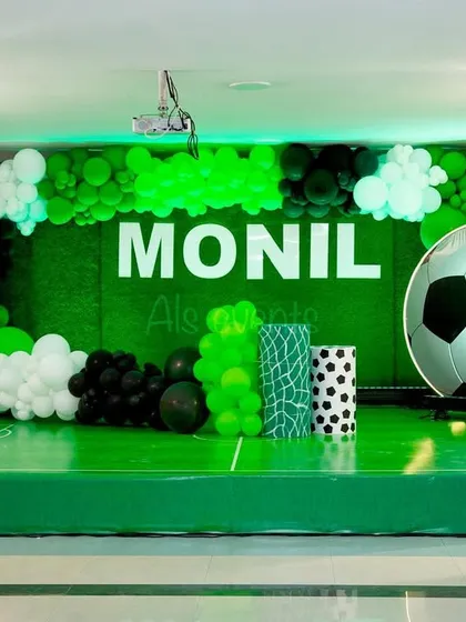 A winning goal for a football fan's birthday. I transformed the stage into a mini football field for Monil, complete with a goal, a giant 3D football, and a balloon arch in team colors.
