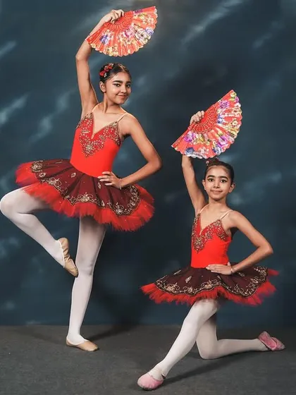 Dancers from our 'Don Quixote' performance. The use of fans as props adds a fiery, Spanish-inspired flair to the classic ballet choreography, showcasing both technique and personality.
