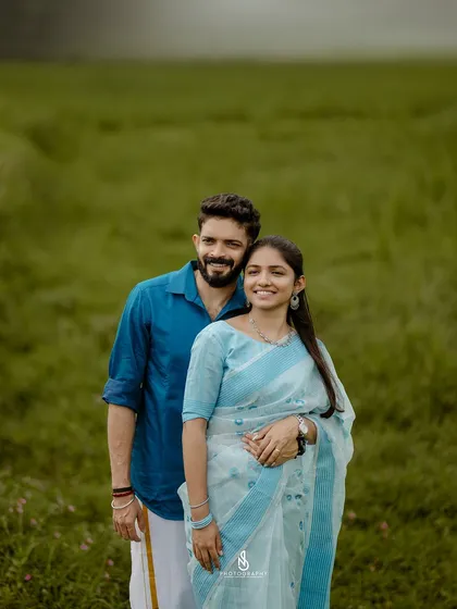 A simple and beautiful portrait of the couple. The man's blue shirt and the woman's light blue saree create a lovely color harmony.