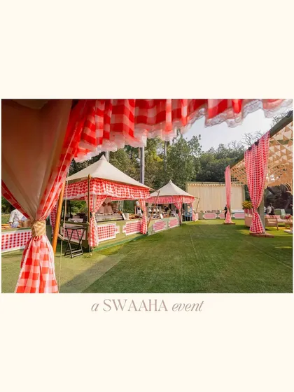 A wide shot of the baby shower setup, showing the charming food stalls and seating areas under checkered-print canopies.