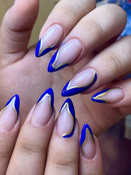 Gold-lined confidence, worn on your fingertips. This sharp almond set features a bold cobalt blue V-French tip, outlined in gold for a modern and regal look.