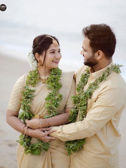 A bright and happy portrait of the couple in their traditional beach attire. The natural smiles and beautiful garlands make this a joyful and authentic pre-wedding photo.