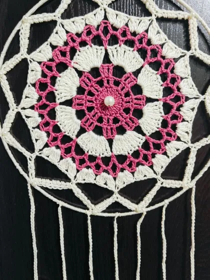 A close-up of the intricate mandala pattern at the center of my crochet dreamcatcher. The pearl detail adds a touch of elegance.