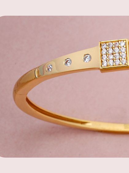 A modern gold kada featuring square panels set with diamonds. The clean lines and minimalist design make it a chic and versatile accessory for any wardrobe.