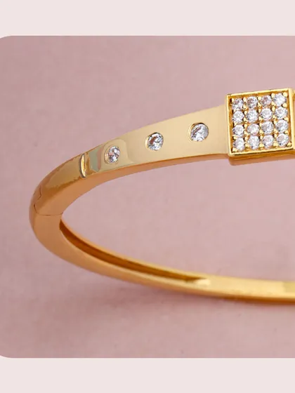 A modern gold kada featuring square panels set with diamonds. The clean lines and minimalist design make it a chic and versatile accessory for any wardrobe.