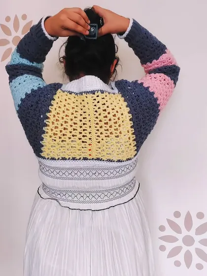 The back view of the Gaea Shrug, a unique piece that combines a shrug with a choker collar. The color-blocked design makes it a true statement piece.