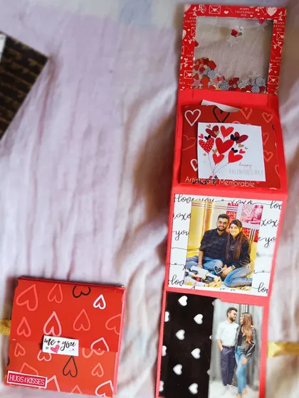 The zig-zag album partially folded, showing the shaker cover and the photos inside.