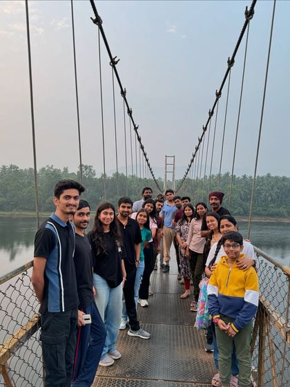 Our group posing on a picturesque suspension bridge over the river during our Gokarna trip, a perfect spot for photos.