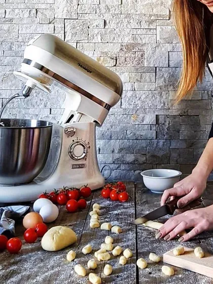 An Ariete vintage stand mixer in action, preparing fresh pasta dough. This powerful appliance combines classic design with the strength needed for various baking and cooking tasks, from kneading dough to whipping cream.