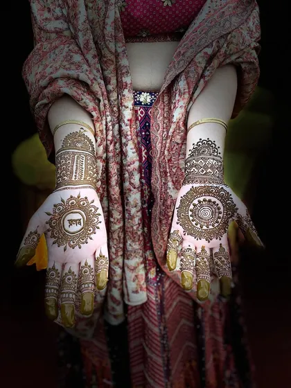 Another view of the personalized 'Ram' mandala design, showcasing the fine details and the balance between the two hands.