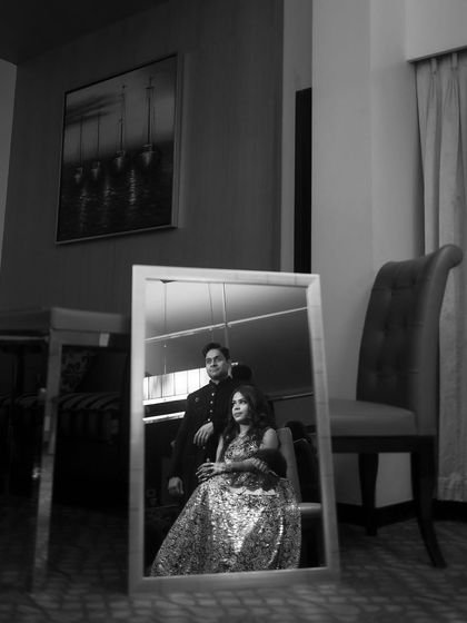 A classic black and white portrait of the couple sharing a quiet moment. The reflection in the mirror adds a layer of artistry to this timeless wedding shot.