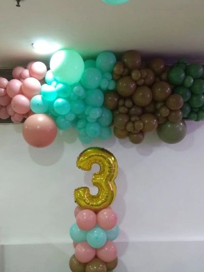 A closer look at the organic balloon garland and number '3' foil balloon, showing how we combine different colors and sizes to create a rich, textured look for this 'Three-Rex' birthday party.
