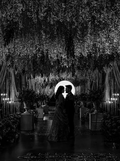 In the quiet moments between celebrations, we find the most profound romance. This artistic silhouette, captured in black and white, uses light and shadow to create a dramatic and intimate portrait that feels like a scene from a classic film.