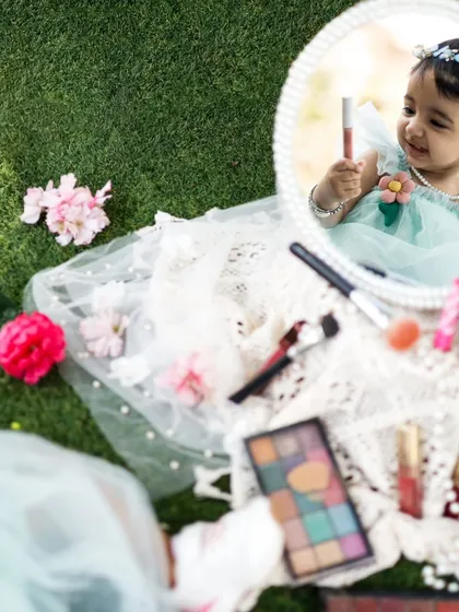 A creative shot showing her reflection as she plays. We love finding unique angles to make your baby's photos extra special.
