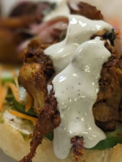 A close-up of the delicious fillings in our Bánh Mì, including savory proteins and a creamy sauce.