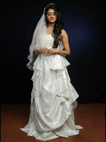 For that classic pre-wedding look, we offer beautiful white bridal gowns for rent. This full-length shot showcases a tiered A-line dress with a delicate veil, perfect for timeless portraits.