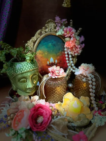 A beautifully lit, artistic shot of our Buddha planter hamper. The arrangement includes a vintage style frame, textured jars, and a lotus shaped candle, creating a serene and spiritual vibe.